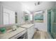 Bright bathroom featuring a large mirror, white cabinets and large shower with beach-themed decorations at 471 Bayshore Rd, Nokomis, FL 34275