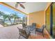 Covered outdoor patio features brick flooring, wrought iron furniture, and a waterfront view with palm trees at 471 Bayshore Rd, Nokomis, FL 34275