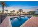 Beautiful pool surrounded by a brick patio, palm trees, and waterfront views at 471 Bayshore Rd, Nokomis, FL 34275