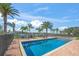 Sparkling pool surrounded by brick pavers, lounge chairs, palm trees, and a view of the water at 471 Bayshore Rd, Nokomis, FL 34275