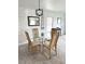 Bright dining room features a modern chandelier and a glass-topped dining table with seating for four at 495 Schooner St, North Port, FL 34287