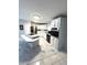 Angle view of the Kitchen featuring an island cooktop, oven, stainless refrigerator and white cabinets at 495 Schooner St, North Port, FL 34287