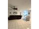Open-concept living area featuring tile floors, a ceiling fan, and a brown leather reclining sofa at 495 Schooner St, North Port, FL 34287