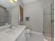 Modern bathroom featuring marble countertops, sleek fixtures, and a frameless glass shower with gray tile at 500 Padova Way, North Venice, FL 34275