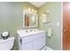 Bathroom features a single sink and white cabinets beneath light green walls with white trim at 501 Dona Dr, Nokomis, FL 34275