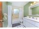 A full bathroom showcases a tub with shower, single sink, and white cabinets against light green walls at 501 Dona Dr, Nokomis, FL 34275