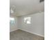 Bright bedroom with neutral paint, tile floor, and two windows providing natural light at 501 Dona Dr, Nokomis, FL 34275