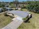 Aerial view of single Gathering home with large driveway and well-maintained lawn near the water at 501 Dona Dr, Nokomis, FL 34275