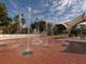 Interactive fountain with jets of water shooting up from the tiled ground under a partly cloudy sky at 501 Dona Dr, Nokomis, FL 34275
