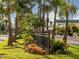 Beautifully landscaped street with black fence, palm trees, and colorful flowers lining the sidewalk at 501 Dona Dr, Nokomis, FL 34275