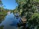 This scenic shot features a waterway with boats, a dock, and lush trees at 501 Dona Dr, Nokomis, FL 34275