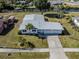 Aerial view of a well-maintained home with a spacious driveway and lush green lawn in a neighborhood at 506 Buena Vista Dr, Nokomis, FL 34275