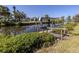 View of a private boat dock with a boat lift on a serene canal, nestled amidst green foliage at 506 Buena Vista Dr, Nokomis, FL 34275