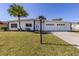 Charming single-story home featuring a well-manicured lawn, a large palm tree, and a three-car garage at 506 Buena Vista Dr, Nokomis, FL 34275