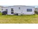 Exterior view of the home with grassy yard, AC and partial view of community at 508 Blackburn Blvd, North Port, FL 34287