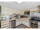 Galley kitchen with stainless appliances, mosaic backsplash, and laminate flooring at 508 Blackburn Blvd, North Port, FL 34287