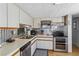 Galley kitchen showcasing stainless appliances, mosaic tile backsplash, and laminate flooring at 508 Blackburn Blvd, North Port, FL 34287