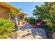 Beautifully landscaped yard with brick-paved walkway, lush greenery, and a cozy lounge area, enhancing the home's curb appeal at 516 Dante St, Venice, FL 34285