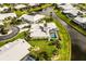 Stunning aerial view of a property with a pool, surrounded by lush landscaping and a scenic canal at 557 Warwick Ct, Venice, FL 34293