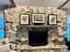 Stone fireplace with decorative art on the mantle and stylish accent chair nearby at 557 Warwick Ct, Venice, FL 34293