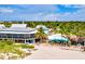 Beachside view of a restaurant with outdoor seating and palm trees, perfect for a tropical getaway at 632 Valencia Rd, Venice, FL 34285