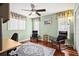 Cozy bedroom with stylish decor, ceiling fan, two windows, and hardwood floors at 632 Valencia Rd, Venice, FL 34285