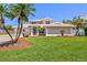 Charming home with a perfectly manicured front lawn and mature palm trees at 632 Valencia Rd, Venice, FL 34285