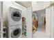 Efficient laundry room with stacked washer and dryer, storage shelves, and easy access to the home at 632 Valencia Rd, Venice, FL 34285