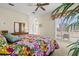 Airy main bedroom with floral-patterned bedspread, shuttered doors to terrace, and view of modern furnishings at 632 Valencia Rd, Venice, FL 34285