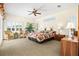 Bright main bedroom with a floral-patterned bedspread, ceiling fan, shutters, and ample natural light at 632 Valencia Rd, Venice, FL 34285