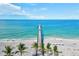 An aerial view of a pier extending into the ocean, with white sand beaches, clear water, and palm trees at 632 Valencia Rd, Venice, FL 34285