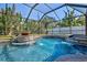 Gorgeous in-ground pool and hot tub area with screened enclosure and tropical landscaping at 632 Valencia Rd, Venice, FL 34285