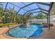 Sparkling pool and spa in a screened enclosure, surrounded by lush tropical plants at 632 Valencia Rd, Venice, FL 34285