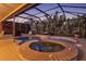 Screened lanai with custom pool, spa and fire pit in an outdoor oasis surrounded by tropical landscaping at 632 Valencia Rd, Venice, FL 34285