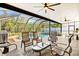 Covered patio with comfortable seating overlooking a beautiful pool and well-maintained landscaping at 632 Valencia Rd, Venice, FL 34285