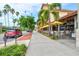 A sidewalk streetscape lined with mature palm trees and outdoor dining under yellow umbrellas at 632 Valencia Rd, Venice, FL 34285