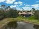 Beautiful backyard featuring a pond behind the home and well-maintained yard with tropical trees at 7120 Grassland Ct, Sarasota, FL 34241