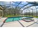 Screened-in swimming pool and hot tub with lush landscaping and serene views at 7120 Grassland Ct, Sarasota, FL 34241