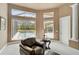 Sitting area with comfortable leather armchair with ottoman, overlooking the screened-in pool and lanai at 7120 Grassland Ct, Sarasota, FL 34241