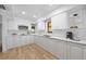 Modern kitchen featuring white cabinets, light countertops, stainless steel appliances, and wood flooring at 718 Golden Beach Blvd # 2, Venice, FL 34285