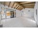 Open living room with vaulted beamed ceilings, tile flooring, and sliders leading to an outdoor patio area at 718 Golden Beach Blvd # 2, Venice, FL 34285