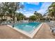 Community pool surrounded by lounge chairs and tropical landscaping creates a relaxing oasis at 748 White Pine Tree Rd # 204, Venice, FL 34285