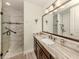 Lovely bathroom with a walk-in shower and elegant vanity with a marble countertop at 830 The Esplanade N # 201, Venice, FL 34285