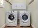 Functional laundry room with front loading washer and dryer and overhead storage cabinets at 830 The Esplanade N # 201, Venice, FL 34285