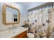 Coastal-themed bathroom with a rope-framed mirror, granite countertop, and a shower curtain featuring sea life at 832 Saintclair Cir # 832, Venice, FL 34285