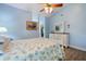 Comfortable bedroom with light blue walls, wood look floors, and a peek into walk-in closet at 832 Saintclair Cir # 832, Venice, FL 34285