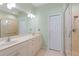 Bathroom featuring double sinks, a large mirror, and a walk-in shower at 8603 46Th Avenue W Cir, Bradenton, FL 34210
