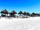 Sandy beach featuring tiki umbrellas, providing shade for people relaxing along the shore with lovely views at 8603 46Th Avenue W Cir, Bradenton, FL 34210