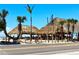 Outdoor beach cafe featuring tropical thatched roofs, surrounded by palm trees, and a road in the foreground at 8603 46Th Avenue W Cir, Bradenton, FL 34210