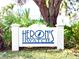 Entrance sign to Heron's Watch community with lush landscaping and mature trees at 8603 46Th Avenue W Cir, Bradenton, FL 34210